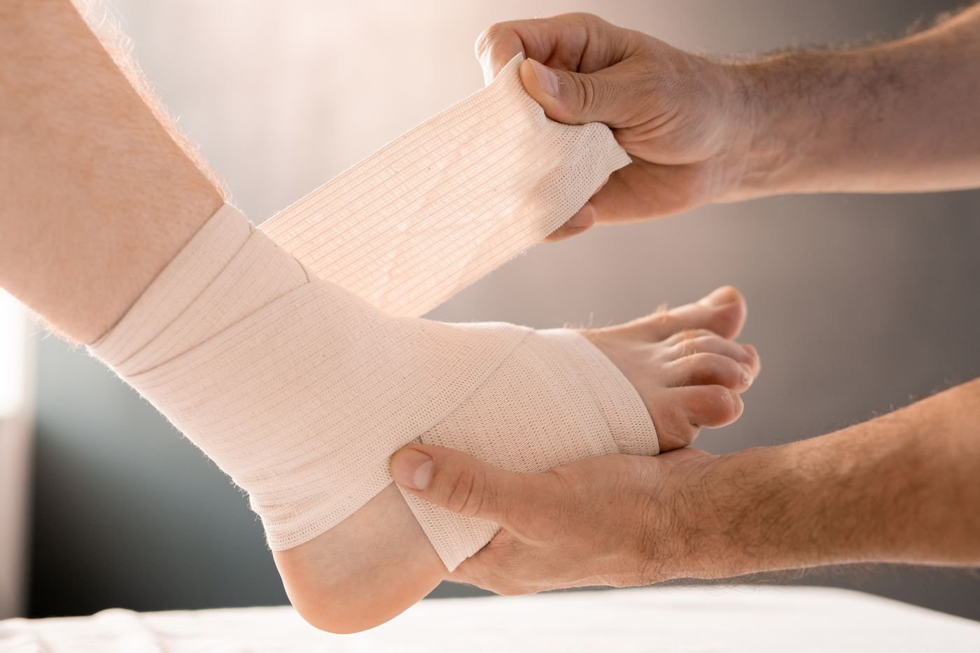 Ankle injury being wrapped with a compression bandage