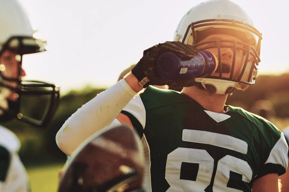 Football player drinking water during practice